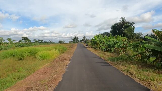 POV Motorcycle Riding: Java, Indonesia, South East Asia: Riding Motorcycle in Vast Farmland Under Blue Sky &ndash; POV