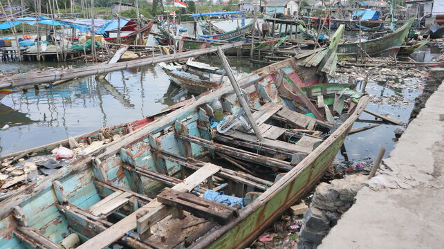 A damaged traditional fishing boat that sits at the estuary towards the beach. This boat is usually used by fishermen to catch fish in the middle of the sea.