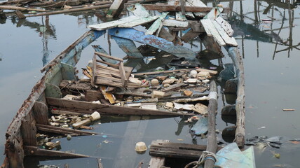 A damaged traditional fishing boat that sits at the estuary towards the beach. This boat is usually used by fishermen to catch fish in the middle of the sea.