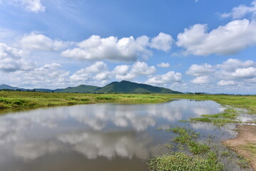 Cloudy Blue Sky and Mountains Mirrored on Calm, Transparent Water