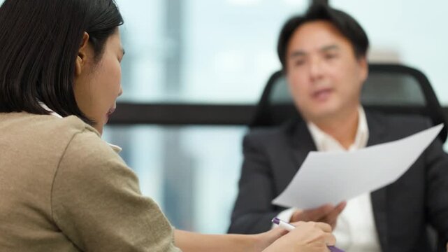 Serious Business Meeting Reviewing Documents in Modern Office