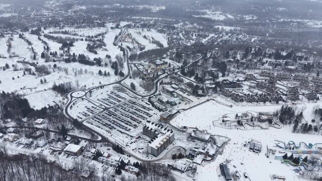 Aerial winter view of Bromont ski resort with snowy slopes, village and parking area in Quebec, Canada. g.