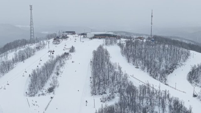 Aerial winter view of Bromont ski resort with snowy slopes, village and parking area in Quebec, Canada. g.