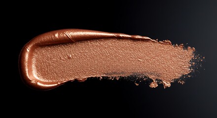Close-up of bronze makeup smudge on black background