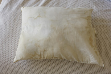 Obraz premium Old and dirty pillow lying on a bed