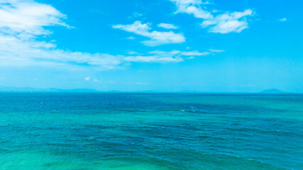 Obraz premium Nature of the ocean and blue sky Summer with sunshine, sandy beaches, clear blue waters sparkling against the blue sky. on an island with good ecology and environment Background for summer vacation