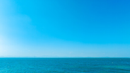 Obraz premium Nature of the ocean and blue sky Summer with sunshine, sandy beaches, clear blue waters sparkling against the blue sky. on an island with good ecology and environment Background for summer vacation