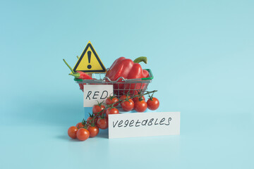 Red vegetables and fruits, sweet and hot peppers, grapes and cherry tomatoes in close-up on a light background and the inscription "red vegetables"
