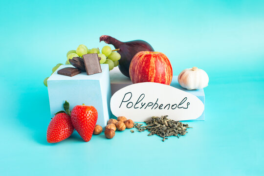 Products containing useful polyphenols in their composition. Grapes, onions, garlic, chocolate and other products in close-up on a light background and the inscription on paper "polyphenols".
