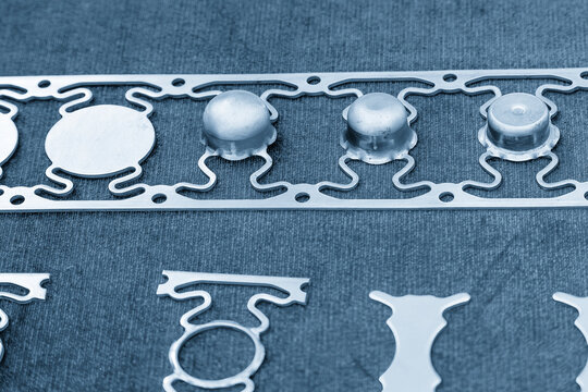 Sample of stamping part of metal drawing process on the progressive die in the light blue scene.