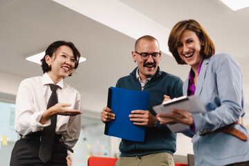 Business professionals collaborate in a modern office setting, sharing ideas and enjoying a...