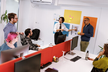 Business meeting in a modern office with a diverse group discussing ideas and projects while collaborating on innovative solutions