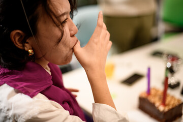 Celebration moment with businesspeople enjoying cake and joyful interactions in a lively office setting during a team gathering in the evening