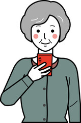 Fototapeta premium 正面向き。スマホを見るカーディガンを着た高齢女性。