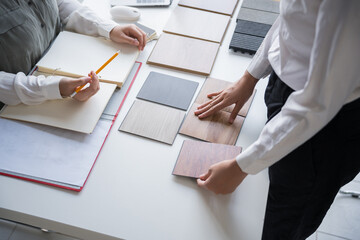 Client and interior designer selecting materials for home decoration in collaborative consultant