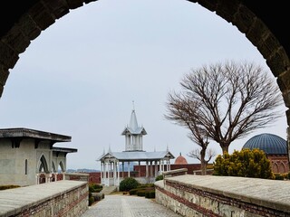 Pointed-roof gazebo at Rabati Castle, Georgia, with wooden beams and open sides, blending traditional design with the medieval fortress surroundings