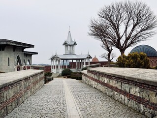 Wooden pavilion with a pointed roof at Rabati Castle, Georgia, featuring open sides, decorative details, and offering a scenic spot within the historic fortress complex