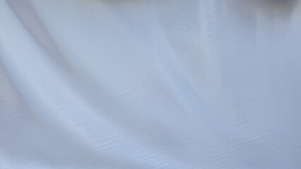 The white canvas is wrinkled and creased. White fabric texture with wrinkled texture. Wrinkles and texture for background or design element, texture, and background. Old fabric with stains.