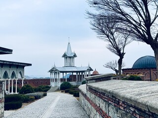 Decorative pavilion with a pointed roof inside Rabati Castle, Georgia, reflecting oriental influences and modern restoration, set against medieval stone walls and landscaped grounds