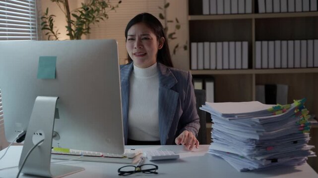 Frustrated Asian businesswoman feeling overwhelmed by a heavy workload while working late in the office. Sad employee shouting in anger