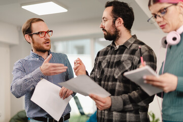 Business professionals collaborating in a modern office setting while discussing project details and sharing ideas in a creative environment