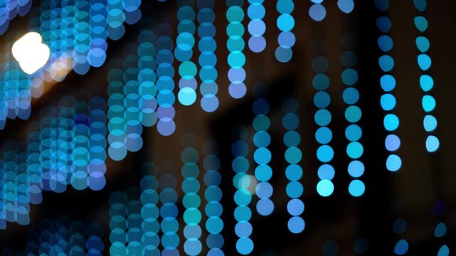 Abstract colorful bokeh lights video with defocused serial lighting. Soft blurred blue and cyan circles create a modern glowing background, ideal for creative motion graphics and elegant overlays.