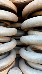 Close-up view of large metal springs stacked together, showcasing their coiled structure and texture