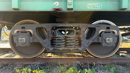 A close-up view of a train wheel assembly, showcasing the wheel, axle, and suspension system, with visible markings and details
