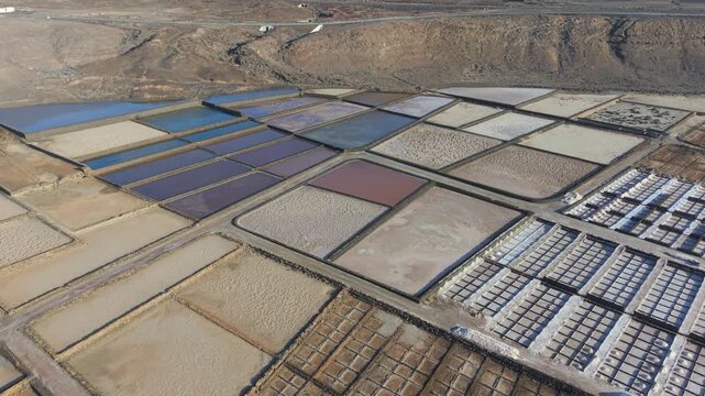 High aerial perspective of the colorful Salinas de Janubio salt pans in Lanzarote, Canary Islands