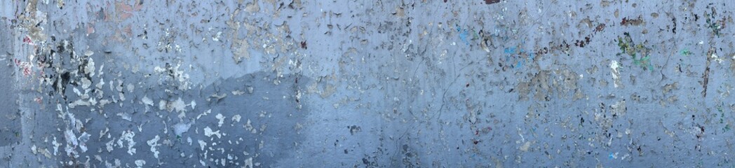 A textured surface with peeling paint in shades of blue and gray, creating an abstract pattern