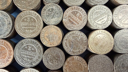 A collection of vintage Russian Empire coins stacked closely together, showcasing various designs and inscriptions, with a focus on their metallic textures and colors