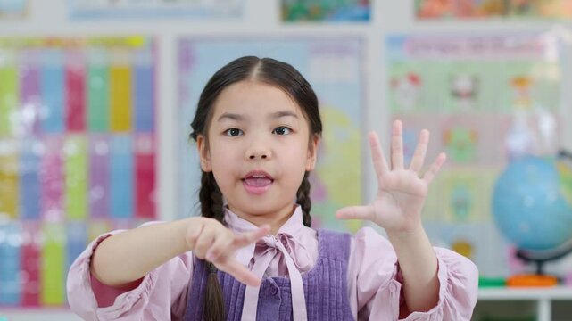 Young Girl Counting on Fingers in Classroom Setting