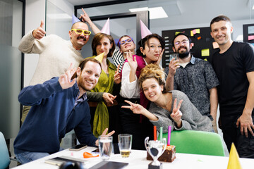 Celebration with diverse businesspeople in modern office space, enjoying a team event with decorations and treats