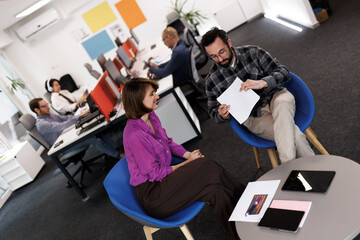 Business meeting in modern office with professionals discussing ideas while seated in comfortable chairs during a productive workday