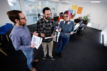 Team members collaborate in an office setting, discussing strategy and reviewing documents during a focused meeting in a modern workspace