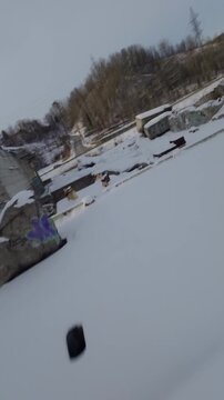 Belgo Factory Shawinigan Quebec Canada FPV drone flying low over snow covered industrial yard, abandoned paper mill with silos during winter.