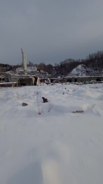 Belgo factory Shawinigan Quebec Canada FPV drone flight through abandoned industrial ruins covered in snow, vertical view with winter decay and cold weather.
