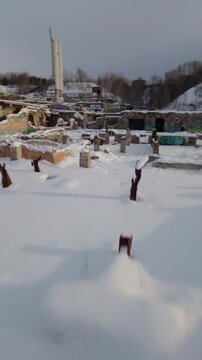 Belgo factory Shawinigan Quebec Canada FPV drone speed flight through abandoned industrial ruins covered in snow, vertical aerial view with raw winter decay atmosphere.
