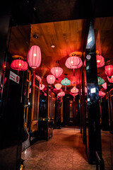 A hallway decorated with multiple red and turquoise lanterns creating a warm and stylish ambiance.