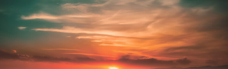 Fototapeta premium Warm Tropical Sunset With The Sun Resting On The Horizon Beneath Soft Cream And Coral Clouds, Surrounded By Teal Sky Tones That Blend Into A Gentle, Dreamy And Romantic Evening Seascape