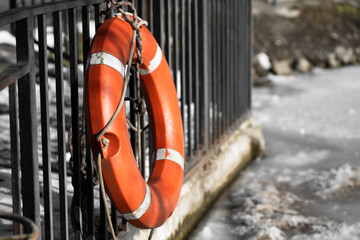 Orange lifebuoy close-up on a background of frozen lake