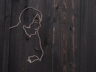 木製の壁に釘で形作られた顔の横顔