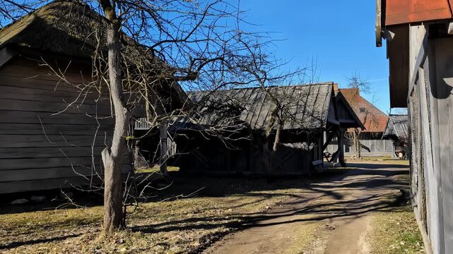 Empty dirt road lined with wooden buildings at Cinevilla Studio, a historical movie town in rural Latvia