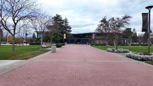 Walking through CSU Stanislaus in Turlock, the camera follows campus pathways past campus architecture and green spaces, reflecting the relaxed pace and organized layout of the university grounds.