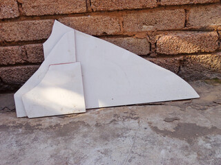 Geometric concrete fragments create an abstract still life against a textured brick wall, blending raw material with minimalist form.