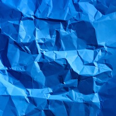 Close-up of intensely crumpled, vibrant blue paper, shadows prominent