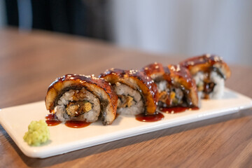 Unagi roll. Grilled eel with sauce served on plate