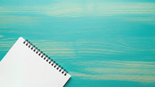 Blank spiral notebook on teal wood background with copy space for add text - Powered by Adobe