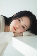 Obraz premium 白い机に伏せる女性