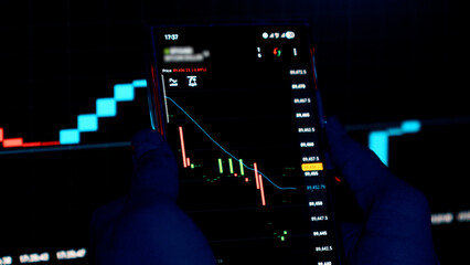 Professional trader analyzing stock market charts on a smartphone